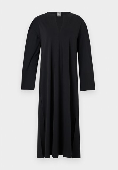 Mustassa pitkähihhaisessa mekossa on V-pääntie ja se on valmistettu sileästä kankaasta. Mekossa on sivuventtiilit, rento istuvuus ja saumatonta olkapään muotoilua.