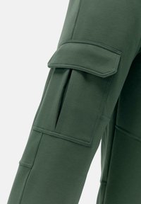 Zelené cargo nohavice so soft materiálom, bočnými vreckami so klapkami a prešitými detailmi pozdĺž švov.