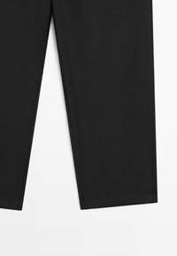 Pantaloni neri con un tessuto liscio e opaco, modello dritto e orlo pulito. Presentano cuciture minime e nessun hardware o motivo visibile.