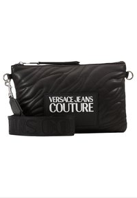 Clutch in pelle nera con motivo a onda trapuntato, caratterizzato da una patch con logo e una tracolla removibile. Progettato con chiusura a zip e dettagli in argento.