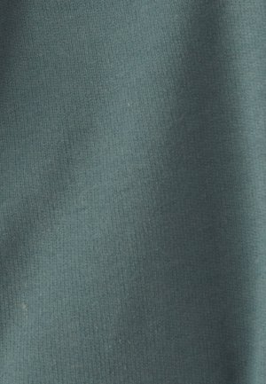 Tela suave en tono teal, con una textura lisa, que muestra sutiles variaciones de color y un patrón ligeramente jaspeado.