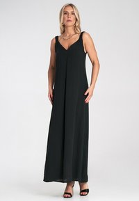 Schwarzes Maxikleid mit V-Ausschnitt und verstellbaren Trägern. Hergestellt aus leichtem Stoff, mit Falten und lockerem Schnitt.