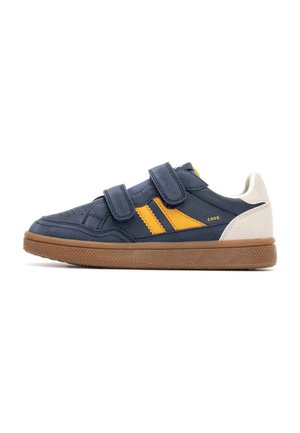 Zapatillas de color azul marino con rayas amarillas, doble correa de velcro y suela de goma. Presentan texturas lisas y de ante.