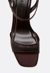Sandale brune pour femmes avec bout carré, fine bride à la cheville et semelle intérieure de marque indiquant la taille 37.