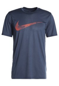 Mörkblå kortärmad sporttröja med ett stort rött Nike-logotyp på bröstet.