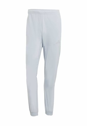 Pantalons de sport gris clair avec une coupe ajustée, taille élastique, poignets resserrés et un détail de logo discret, fabriqués en matériau qui évacue l'humidité.