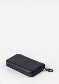 Portafoglio in pelle navy con chiusura a zip, forma rettangolare, superficie liscia e un sottile dettaglio del marchio sulla parte anteriore.
