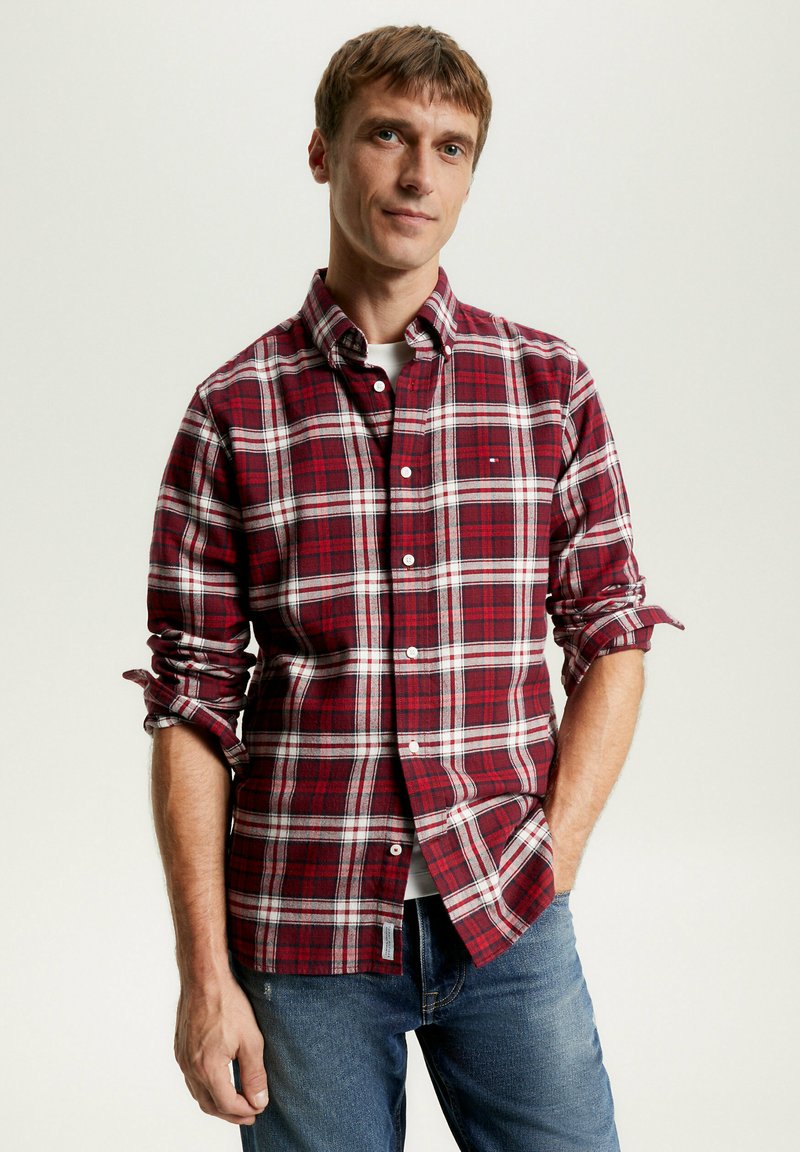 Camicia di flanella a quadri rossi e bianchi con colletto button-down, caratterizzata da maniche lunghe arrotolate ai polsi e un dettaglio della tasca frontale.