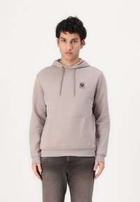 Ανοιχτό γκρι φούτερ με καπάκι, με μπροστινή τσέπη, κορδόνια και λογότυπο στην περιοχή του στήθους. Ριμπ τουνίκ και στρίφωμα. Λείο βαμβακερό υλικό.