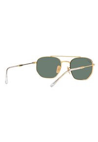 Occhiali da sole in metallo dorato con lenti verdi ottagonali. Astine trasparenti con una leggera curvatura. Presentano un doppio ponte e cuscinetti per il naso.