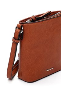 Brun syntetisk læder skuldertaske med en tekstureret overflade, lynlåslukning, justerbar rem og sølvfarvet logo detalje på forsiden.