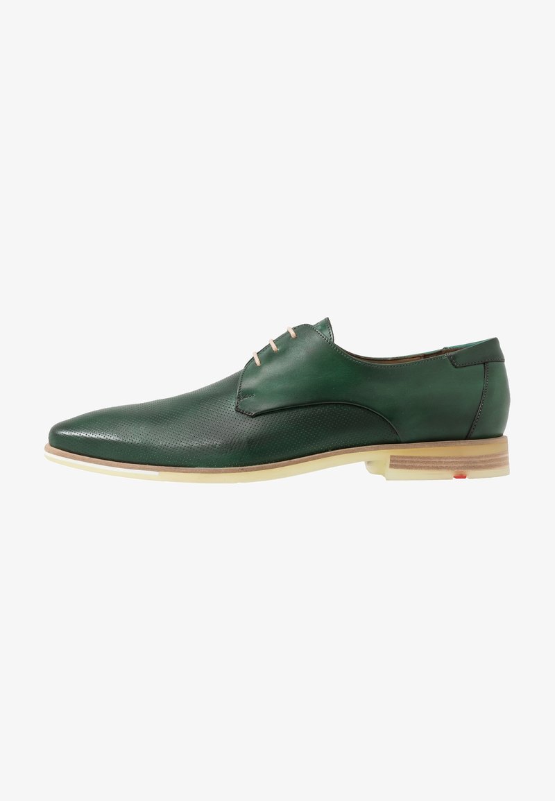 Chaussure habillée pour homme en cuir vert foncé avec semelle beige clair et trois lacets blancs, vue de profil sur fond blanc.