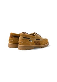 Paire de mocassins en daim beige avec des détails marron et beige, semelles épaisses en caoutchouc, et lacets, vus de dos sur fond blanc.