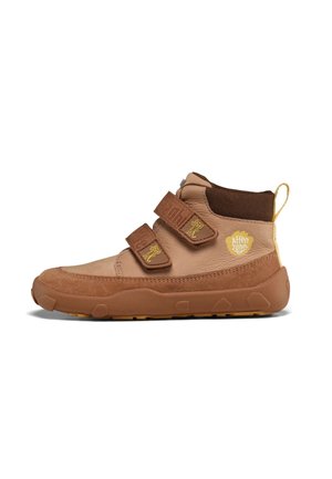 Hellbrauner Kinderschuh mit zwei Klettverschlüssen, gelbem Branding, Gummisohle und Fersenschlaufe, in linker Seitenansicht abgebildet.