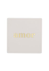 Scatola quadrata bianca con superficie testurizzata, caratterizzata dalla parola "amor" in lettere minuscole dorate in rilievo al centro nella parte superiore.