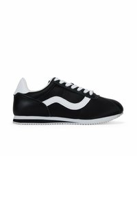 Black athletic shoes with white accents, featuring a textured upper, round toe, and flat rubber sole. Laces are white and evenly spaced.