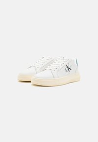 Witte sneakers met een gestructureerde rubberen zool, een glad leren bovenwerk en teal accenten bij de hiel. Voorzien van veters en logo-details aan de zijkant.