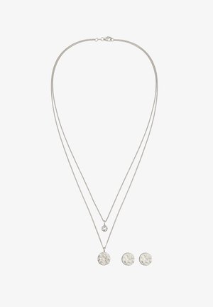 Sølvfarvet lagdelt halskæde med to kæder, en med en rund vedhæng og en med en tekstureret cirkulær detalje. Inkluderer matchende øreringe.