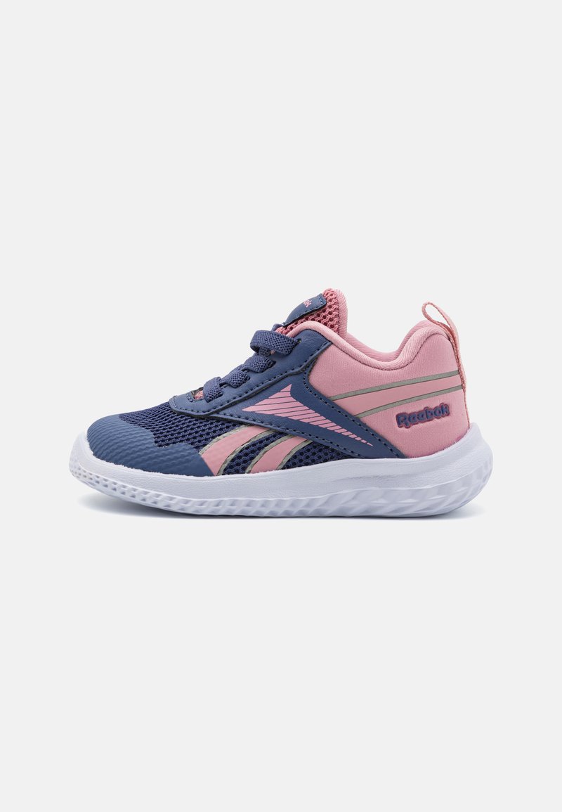 Zapatilla deportiva azul y rosa con parte superior de malla, cordones y suela blanca ligera. Presenta el logotipo de Reebok en el lateral y en el talón.