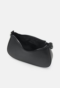 Pochette bracelet en cuir noir avec ouverture zippée, montrant l'intérieur vide et une petite anse en boucle d'un côté.