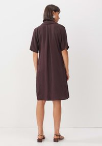Braunes kurzärmliges, knöpfbares Kleid mit lockerer Passform, gefertigt aus leichtem Stoff. Verfügt über einen spitzen Kragen und einen mittellangen Saum.