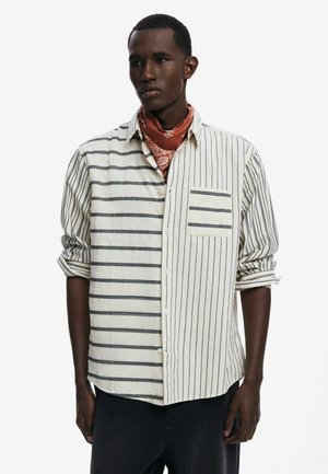 Gestreepte blouse met lange mouwen in lichtroom met donkere strepen, voorzien van een enkele borstzak en opgerolde mouwen. Katoenen materiaal.