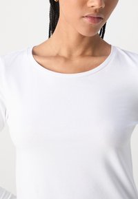 White long-sleeve shirt with a round neckline, made of soft cotton material, featuring a smooth texture and fitted design.