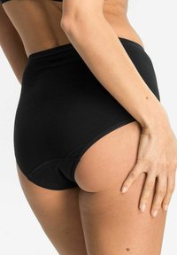 Hochgeschnittene schwarze Baumwollunterwäsche mit einer glatten Textur und Steppdetails, die einen mittelhohen Schnitt und ein Design mit vollständiger Abdeckung aufweist.