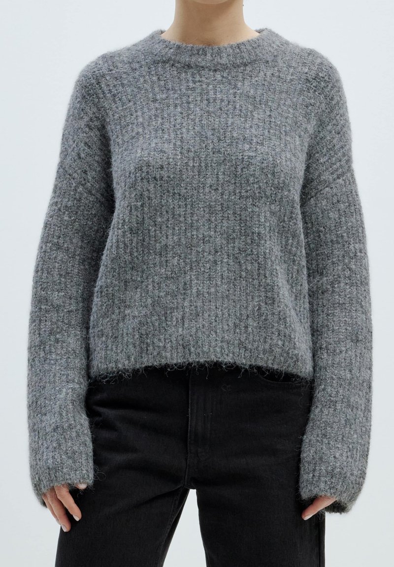 Grau gestrickter Pullover mit einem gerippten Muster, rundem Ausschnitt und überschnittenen Schultern. Der Saum ist leicht verkürzt, mit langen, lockeren Ärmeln.