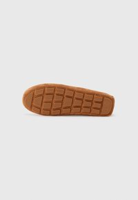 Brown rubber sole with a textured grid pattern, featuring a slightly raised edge and embossed logo. Smooth finish with a sturdy design.