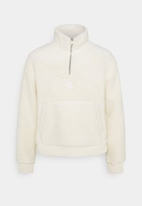 Pullover in pile color crema con colletto alto, zip a metà davanti, logo ricamato e tasca frontale a marsupio; polsini e orlo elasticizzati.