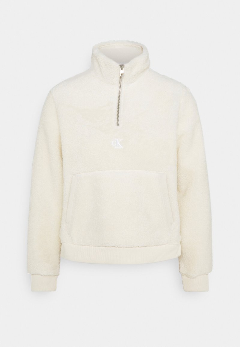 Pullover in pile color crema con colletto alto, zip a metà davanti, logo ricamato e tasca frontale a marsupio; polsini e orlo elasticizzati.