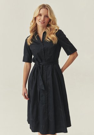 Dark navy button-up dress with short sleeves, a tied waist, and a pleated skirt; features a subtle textured pattern throughout.
