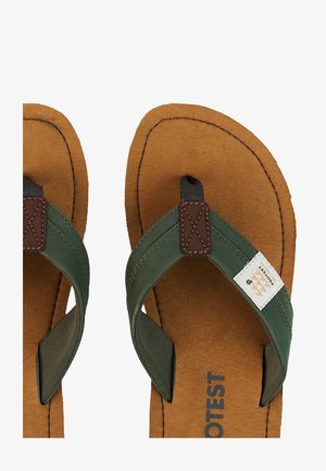 Brown sole flip-flops with green fabric straps, brown leather patch stitching, and a white label reading "Protest" on one strap.
