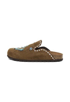 Mule en daim marron avec perle bleue décorative et concho argenté, coutures blanches, semelle en liège avec semelle extérieure noire.