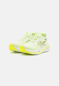 Scarpe da corsa verde lime con una tomaia in mesh traspirante, dettagli neri, suola intermedia bianca spessa e suola gialla testurizzata.