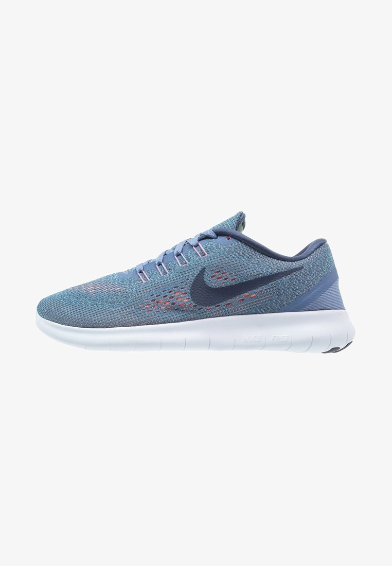 Nike Free running shoe in blue mesh upper with pink accents, black logo, and white sole. Features a sleek, lightweight design.