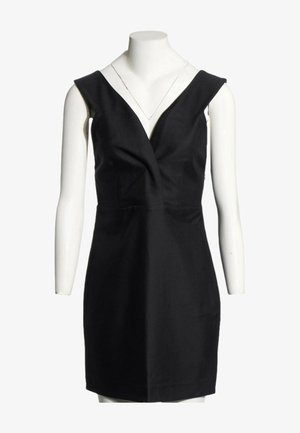 Vestido negro sin mangas con escote en V profundo y cintura entallada mostrado en un torso de maniquí blanco.
