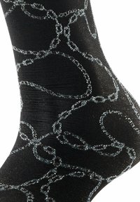 Czarna skarpetka z teksturową powierzchnią i wzorem w srebrny łańcuch, tworzącym efekt błyszczenia. Wzór jest skomplikowany, z różnorodnymi kształtami pętli.