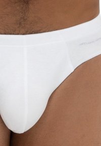 Weiße Baumwollslips mit glatter Textur, elastischem Bund und minimalistischem Design. Keine sichtbaren Muster oder Logos.