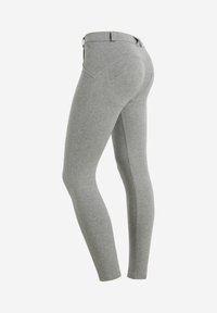 Leggings grigi realizzati in un tessuto morbido e elastico. Presentano una vita liscia e cuciture curve per una vestibilità aderente. Nessuna parte metallica visibile.