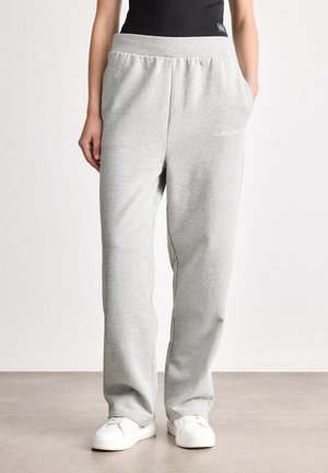 Light gray sweatpants made of cotton blend, featuring an elastic waistband, side pockets, and Calvin Klein logo on the front.