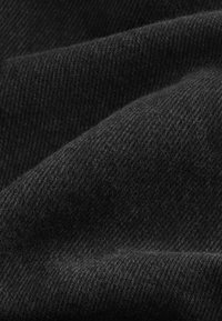 Mustaan deniinikangas, jossa on pehmeä rakenne, hienovarainen taitoskuvio ja poimuja, jotka luovat syvyyttä ja ulottuvuutta.