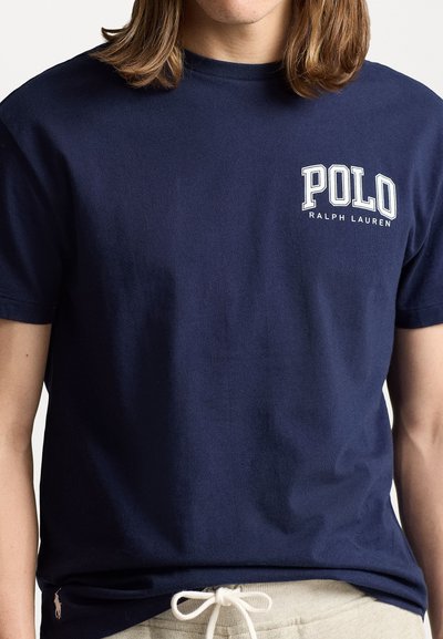 Sötétkék pamut póló rövid ujjakkal, fehér "POLO RALPH LAUREN" logóval a bal mellen. Puha tapintású és kerek nyakkivágású.