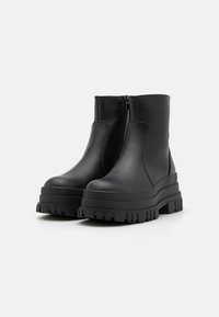 Mustad mustad mustad nahast ankle boots külgse lukuga, paksu platvormi tallaga ja hambulise mustriga, et tagada haarduvus.