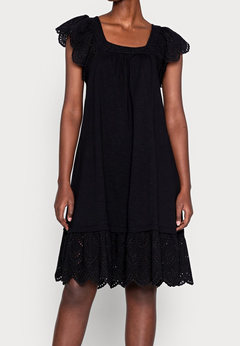 Abito nero con maniche corte arricciate e bordo in pizzo sull'orlo. Il tessuto è leggero e ha una vestibilità ampia.