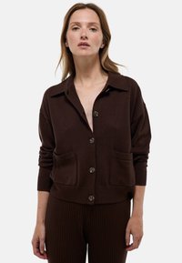 Gilet en tricot marron avec un col, fermeture à boutons et poches avant. Présente des poignets et un ourlet côtelés. Texture douce.