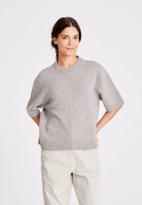 Harmaa, lyhythihainen neulepusero, jossa on resorireunaiset pääntie ja helma, pehmeä koostumus, rento istuvuus ja minimalistinen muotoilu.