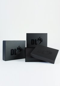 Schwarze Kartonboxen mit matter Oberfläche, die ein dezentes geprägtes Logo und ein Drachendesign präsentieren. Enthält eine offene und zwei geschlossene Boxen.