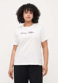 Witte katoenen T-shirt met een ronde hals en korte mouwen, met "Tommy Hilfiger" geborduurd in marineblauw op de borst.